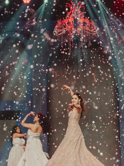 A magical moment from the bride's solo performance, where she is surrounded by a cascade of bubbles under dramatic red lighting, creating a dreamy, unforgettable visual.