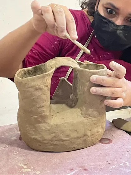 A student works on an abstract, sculptural piece, demonstrating the artistic possibilities beyond functional pottery.