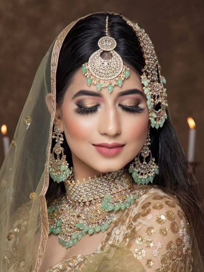 A soft, romantic look featuring a mint-green beaded jewellery set on a model with her eyes closed. The candlelight in the background adds to the dreamy mood.