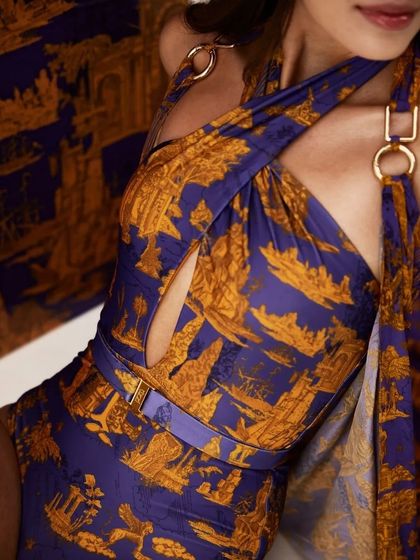 A close-up on the intricate print and hardware details of a swimsuit from Tizzi's "Fotia" collection.