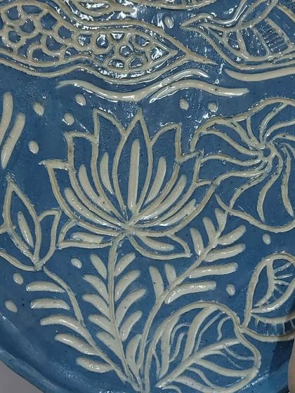This plate features an embossed lotus design, created by carefully pressing textures into the clay. It's a technique I learned from a student, and I love the beautiful, intricate result.