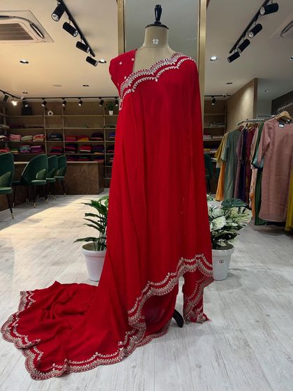 Full-length views of our Chinon party wear sarees, displayed on a mannequin. Available in stunning red and royal blue, these sarees feature intricate scalloped borders and come with a matching pre-stitched embroidered blouse.