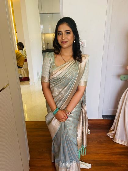 A full-length view of Mahima's look. The simple, chic hairstyle and makeup perfectly complement her beautiful pastel saree.