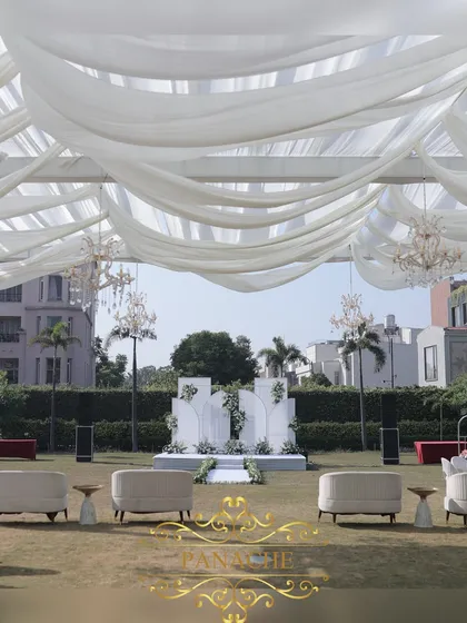 A wide shot of the venue, showing the draped canopy, lounge seating, and the main stage in the distance.