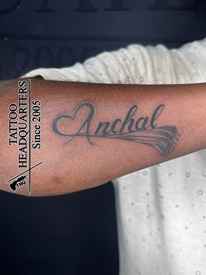The name "Anchal" with a heart and a flourish, a beautiful and personalized script tattoo.