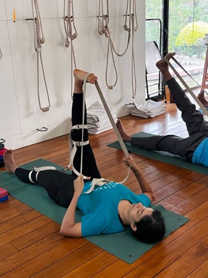 This class is dedicated to 'Nari Shakti', the power of women. Here, students are using belts to work on their leg alignment, a practice that is especially beneficial for hormonal health and stability.