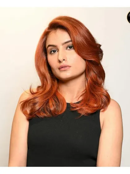 A portrait of the client with the fiery copper red hair, showcasing the colour and the soft, wavy styling.