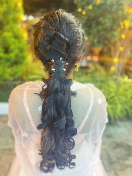 A front view of the beautiful curly ponytail, a great choice for a comfortable yet glamorous party look.