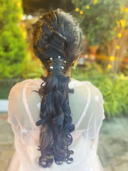 A close-up of the intricate braiding and accessory placement in this modern ponytail style.