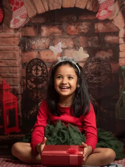 A collection of happy kids enjoying my two distinct Christmas setups: a bright, snowy winter scene and a warm, rustic brick fireplace.