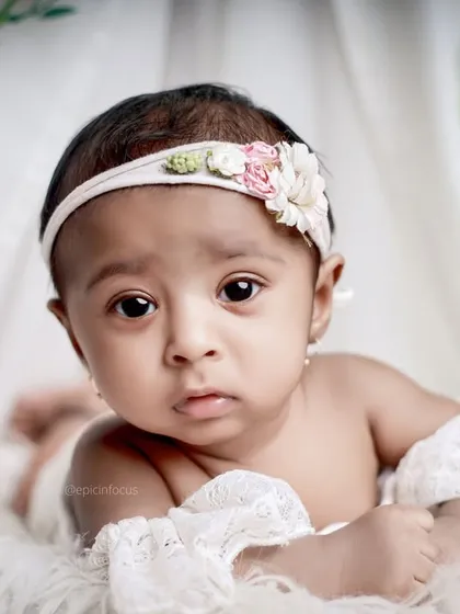 A sweet and simple portrait of a four-month-old baby during her sitter session. The focus is entirely on her beautiful, curious eyes and delicate features.