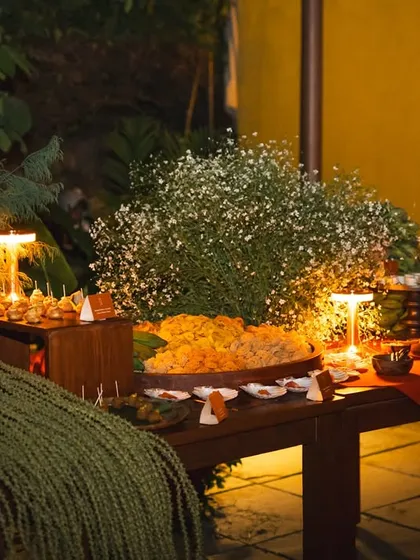 An evening view of a beautifully lit grazing table. The arrangement is both abundant and artfully styled, making it a central feature of the celebration.