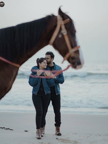 A close-up shot from the beach photoshoot with the horse, focusing on the couple's connection. The horse is framed in the foreground, adding depth and a storytelling element to this romantic portrait.