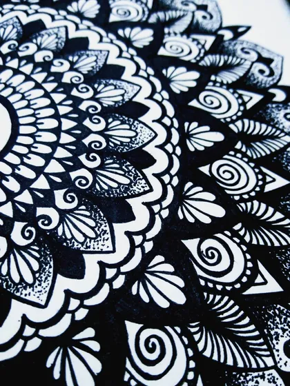 A close-up view of the detailed linework and stippling in my sketchbook mandala. Notice how different patterns like swirls, leaves, and dots work together to create texture and depth.