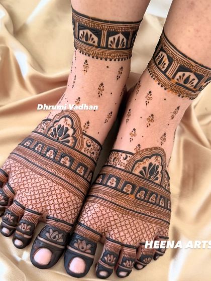 A full-coverage bridal foot mehendi with intricate checkerboard patterns and a beautiful lotus border around the ankle.