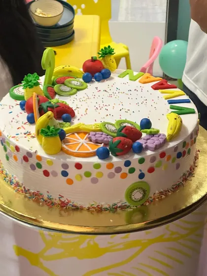 A close-up of a colorful and delicious fruit-themed birthday cake.