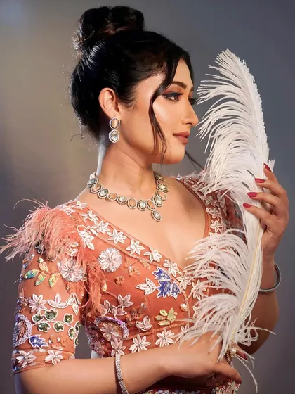 The complete look from our masterclass, featuring a high bun and feather details. Our courses cover both makeup and hairstyling to ensure our students become well-rounded artists.