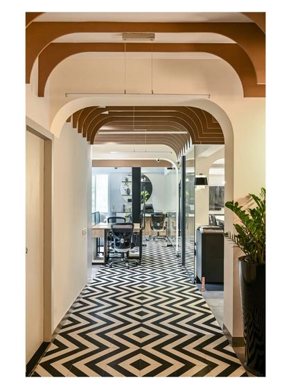 The central corridor's bold geometric tiles lead towards the manager's cabin and other office zones, creating a strong visual path.