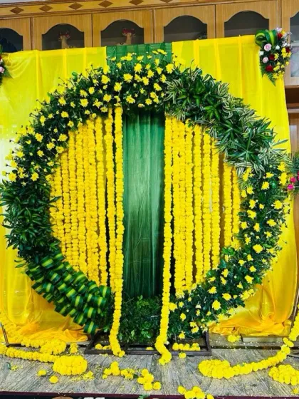 A final look at the vibrant yellow Haldi setup, showing the balance of the entire design. The corner floral bouquets on the stands add a touch of contrasting colour.
