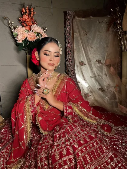 A close-up of the bride's pose, showing the details of the jewelry and the outfit's embroidery.