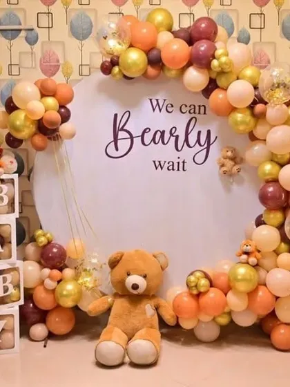 A 'We Can Bearly Wait' teddy bear themed baby shower with a custom backdrop, 'BABY' boxes, and a balloon arch.