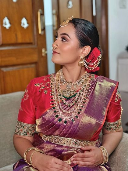 A side profile capturing the regal posture and the stunning layers of diamond and emerald jewellery.