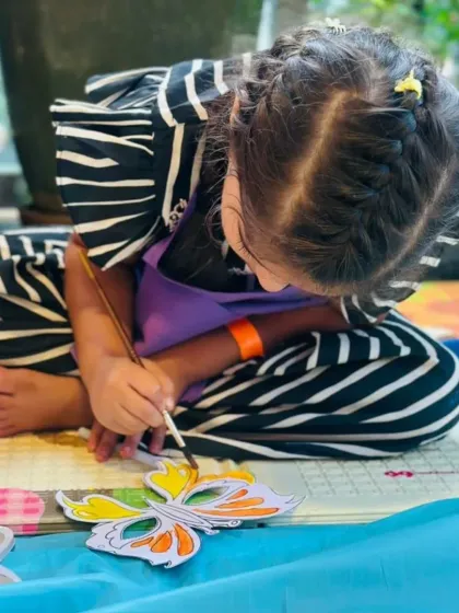 A young guest carefully paints a butterfly, fully absorbed in the activity. I set up individual art stations so each child can work at their own pace and express their unique creativity.