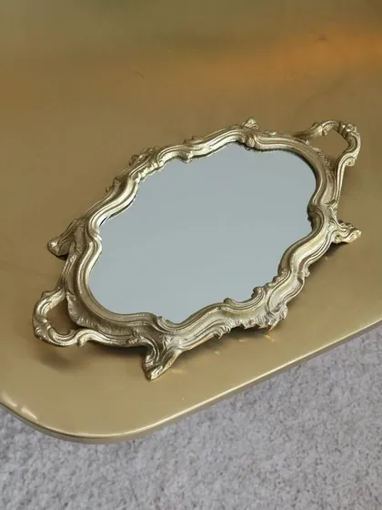 Our vintage-inspired mirror tray with an ornate, baroque-style gold frame. This glamorous piece is perfect for a vanity table, a bar cart, or for serving drinks with a touch of old-world charm.