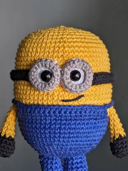 A cheerful Minion, ready to cause some trouble. The goggles and overalls are stitched with care.