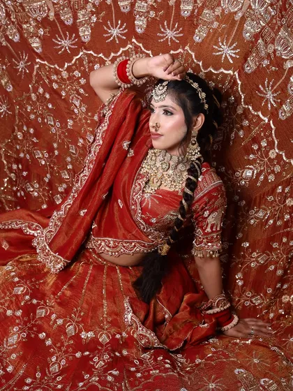 A powerful pose from a student's bridal portfolio. The rich, velvet lehenga is paired with a dramatic eye and perfectly placed jewelry, showing a high level of skill.