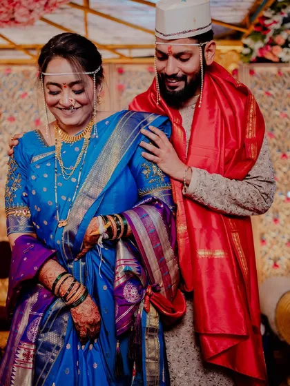The groom lovingly places his hand on his bride's shoulder.
