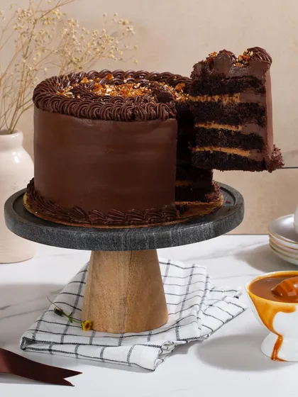 A slice being lifted from my Dark Chocolate & Salted Caramel Cake, showing the rich, dark layers of chocolate cake and silky caramel filling.