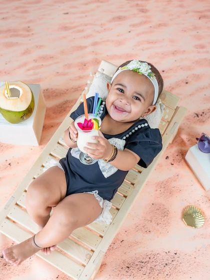 Chilling on the beach with a cool drink. This fun, summery theme uses a beach chair, sand, and tropical props to create a perfect vacation vibe in the studio.