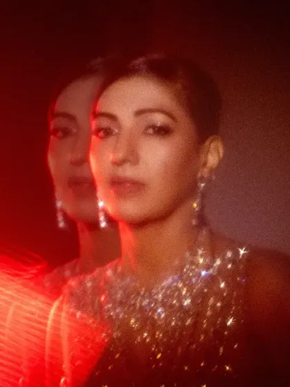 An experimental portrait using red light and a slow shutter to create a ghosting or double exposure effect. This results in a vibrant, energetic, and abstract image.