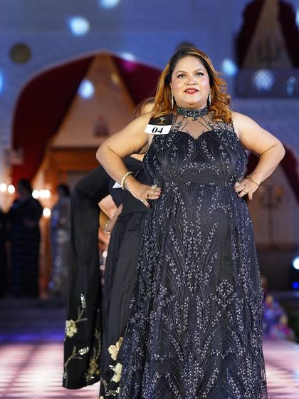 A black plus-size gown with delicate silver embroidery. The A-line cut is classic and flattering.