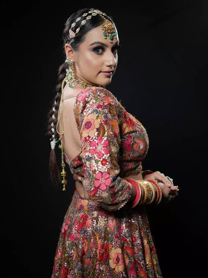 A side profile showcasing a modern bridal braid. This hairstyle is both elegant and practical, keeping the hair neatly styled while adding a touch of tradition with the matha patti and hair accessories.