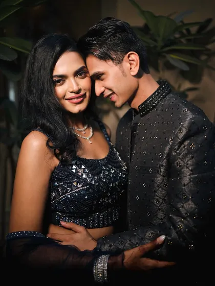 A close, intimate portrait where the bride looks confidently at the camera. The groom's gentle smile as he looks at her creates a beautiful contrast, showcasing their deep connection.