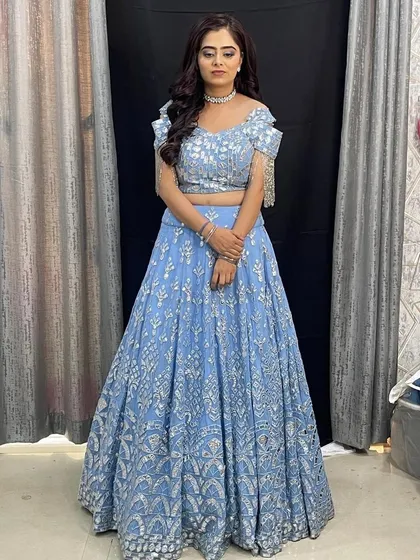 This powder blue lehenga is a fresh and modern choice for a wedding guest or bridesmaid. The off-shoulder blouse with fringe details is so stylish.