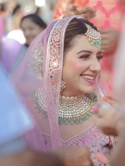 A close-up of a bride's joyful, candid smile. This shot captures the genuine happiness and excitement of the wedding day, framed by the crowd of loved ones.