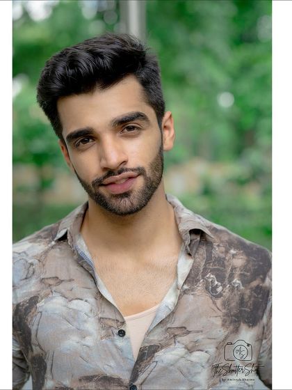 A friendly and approachable headshot taken outdoors. The soft lighting and natural background make this a warm and inviting portrait for an actor or model's portfolio.