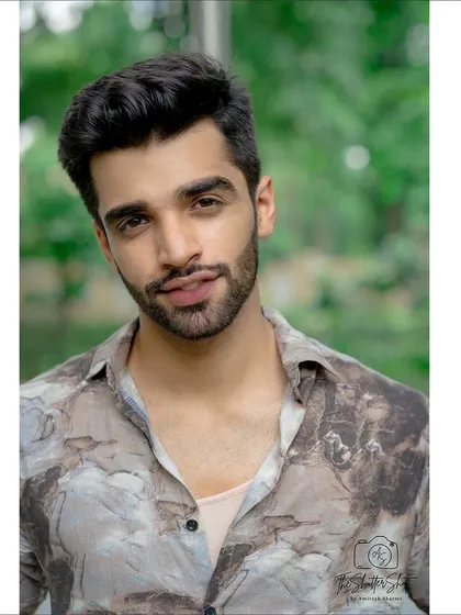 A friendly and approachable headshot taken outdoors. The soft lighting and natural background make this a warm and inviting portrait for an actor or model's portfolio.