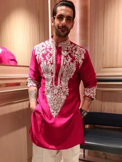The red embroidered kurta paired with white trousers for a classic, sharp contrast.