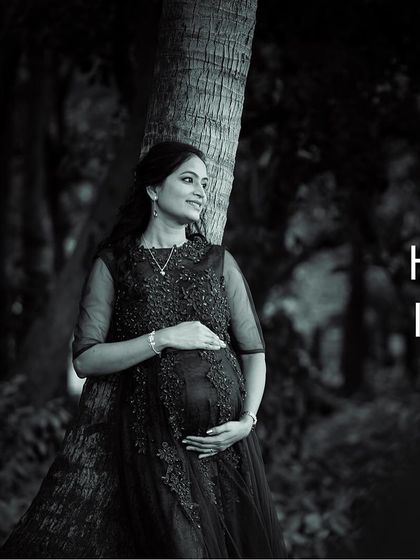 A timeless black and white portrait from an outdoor maternity shoot. This elegant style focuses on the mother-to-be's silhouette and the quiet beauty of the moment, creating a classic and artistic photograph.