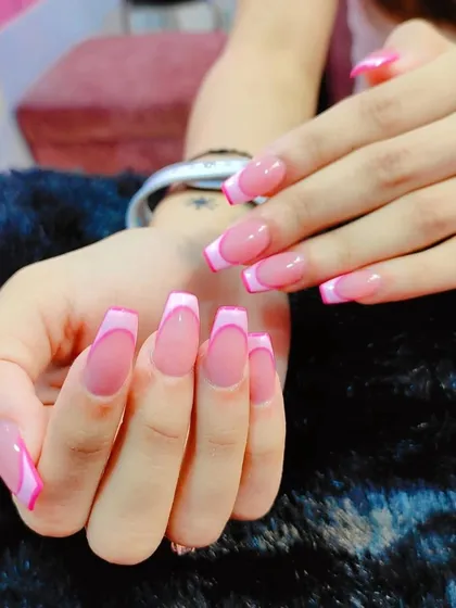 Pretty in pink. This is a playful and feminine take on the French manicure, using two different shades of pink to create a layered, wavy tip on long coffin-shaped nails.