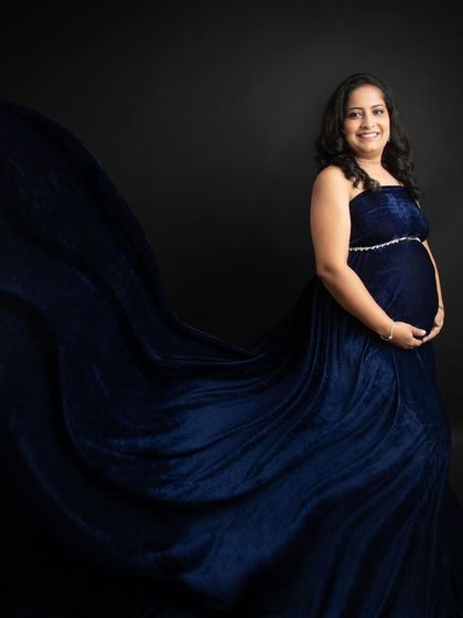 A smiling self-portrait from my own maternity shoot. The rich blue velvet gown and the flowing fabric made me feel so glamorous and confident.