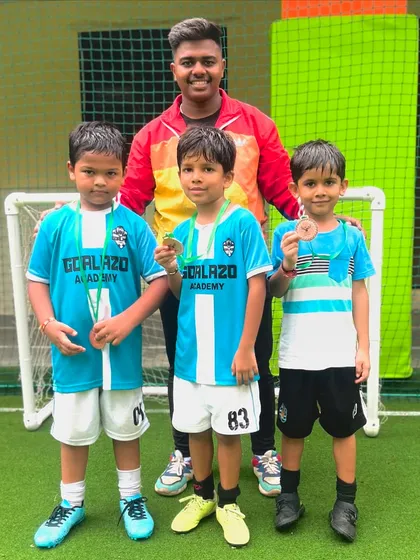 Our coach with the Under-7 players, who are all smiles after picking up medals for their performance.