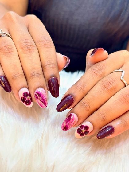 Feeling like a glass of red wine with these nails. This set combines a deep burgundy color with pink marble and floral accent nails.