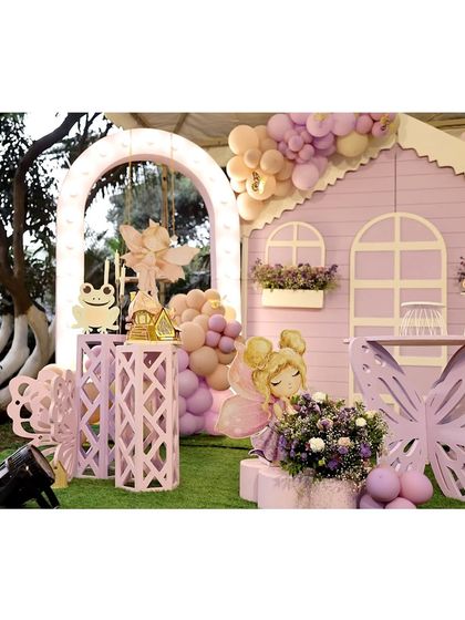 A closer look at the magical fairy house and surrounding decor. The attention to detail, from the flower boxes on the house to the friendly frog prince, makes the theme truly special.