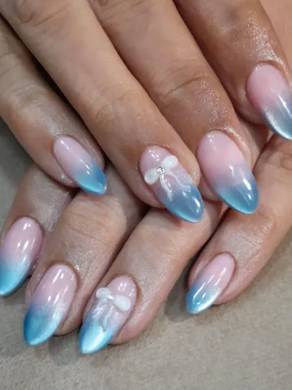 This is our chrome ombre effect, a soft and dreamy design. It blends a natural pink base into a shimmering sky-blue tip, finished with a delicate 3D white bow for a touch of sweetness.