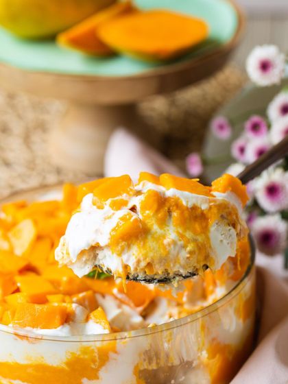 A close-up spoonful of the Mango & Cream Cheese Trifle, showing the perfect ratio of fruit, cream, and cake.